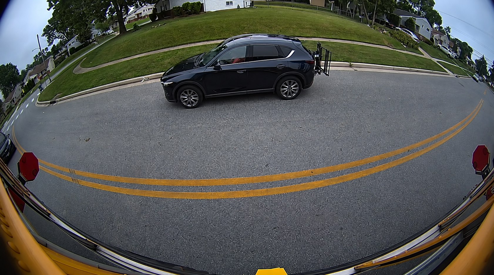 Example wide-angle Stop Arm AI Detection view of the street beside a school bus.
